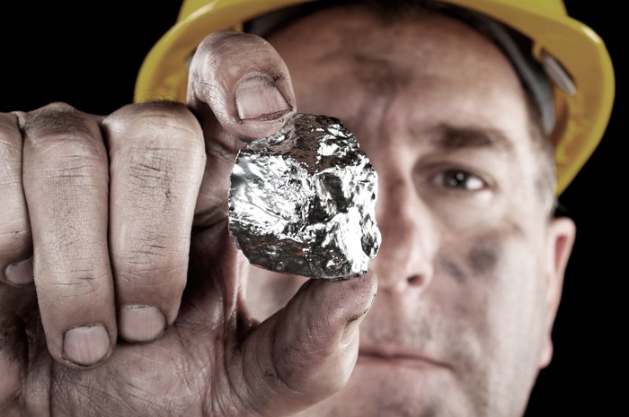 Miner holding up silver nugget