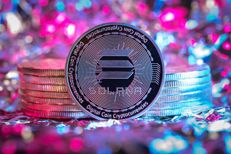 Solana SOL cryptocurrency physical coin, abstract background.